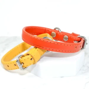 yellow and orange soft leather puppy collars resting on a white marble background, handmade in the UK by Petiquette