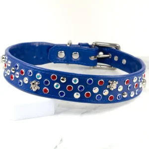 A wide, blue leather dog collar encrusted with Swarovski crystals and silver skull-shaped studs. Made by Petiquette