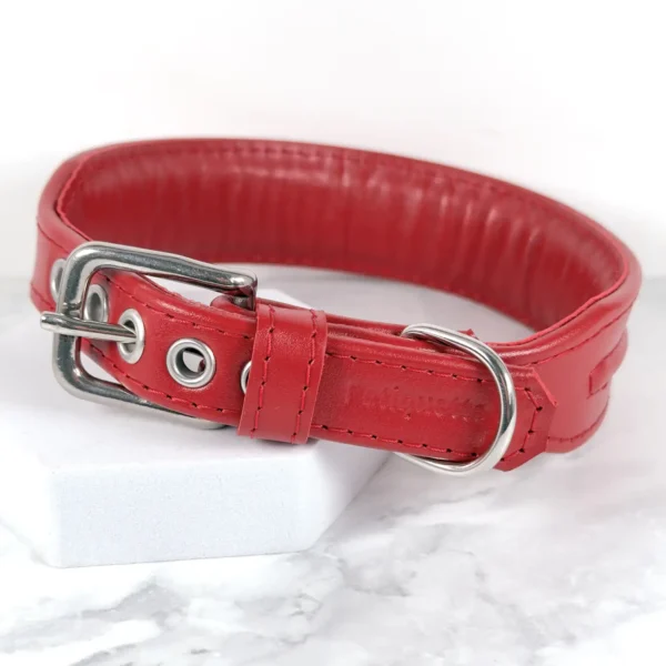 a handmade red leather dog collar against a white marble background, made by Petiquette Collars