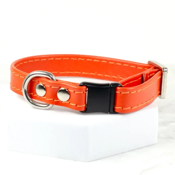 a close up of an orange leather puppy collar with a breakaway clasp made by Petiquette