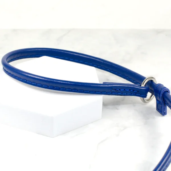 a blue leather sleep lead handmade by Petiquette on a white marble background