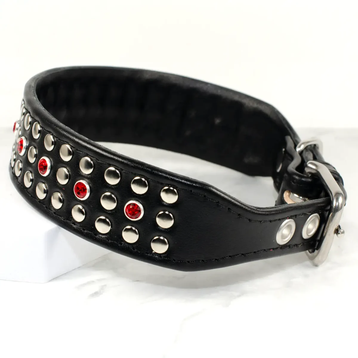 a wide, black leather dog collar covered in silver studs and vibrant red Swarovski crystals, handmade by Petiquette