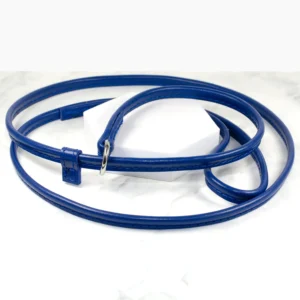 a handmade leather slip lead with a safety keeper in vibrant blue resting on white marble, made by Petiquette Collars